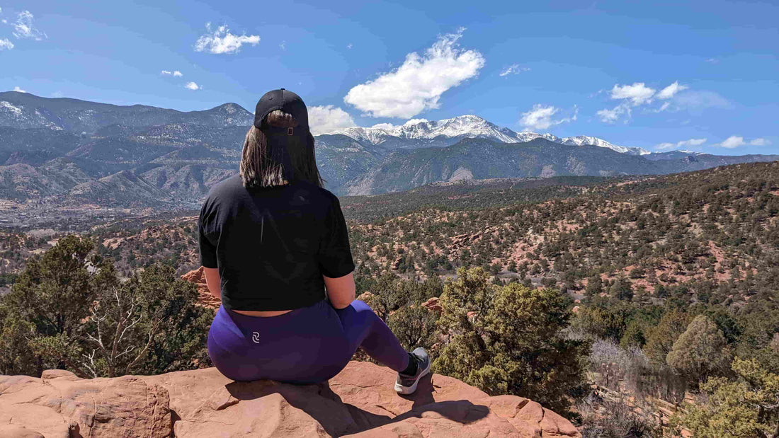 Woman in RECOSIVITY leggings sitting on a rock